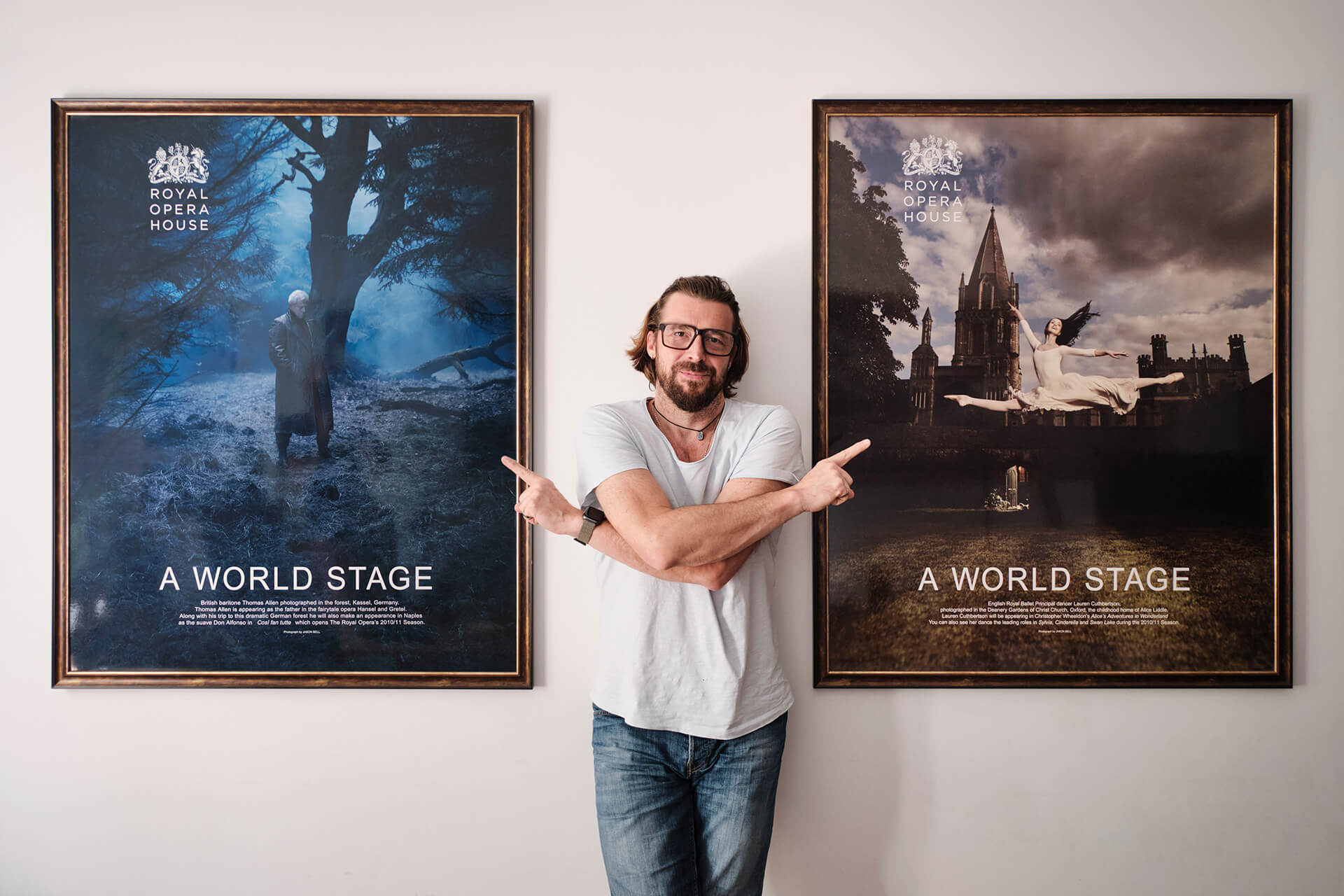 Portrait of Krzysztof Gadomski, CEO of House of Retouching, posing next to Royal Opera House posters.